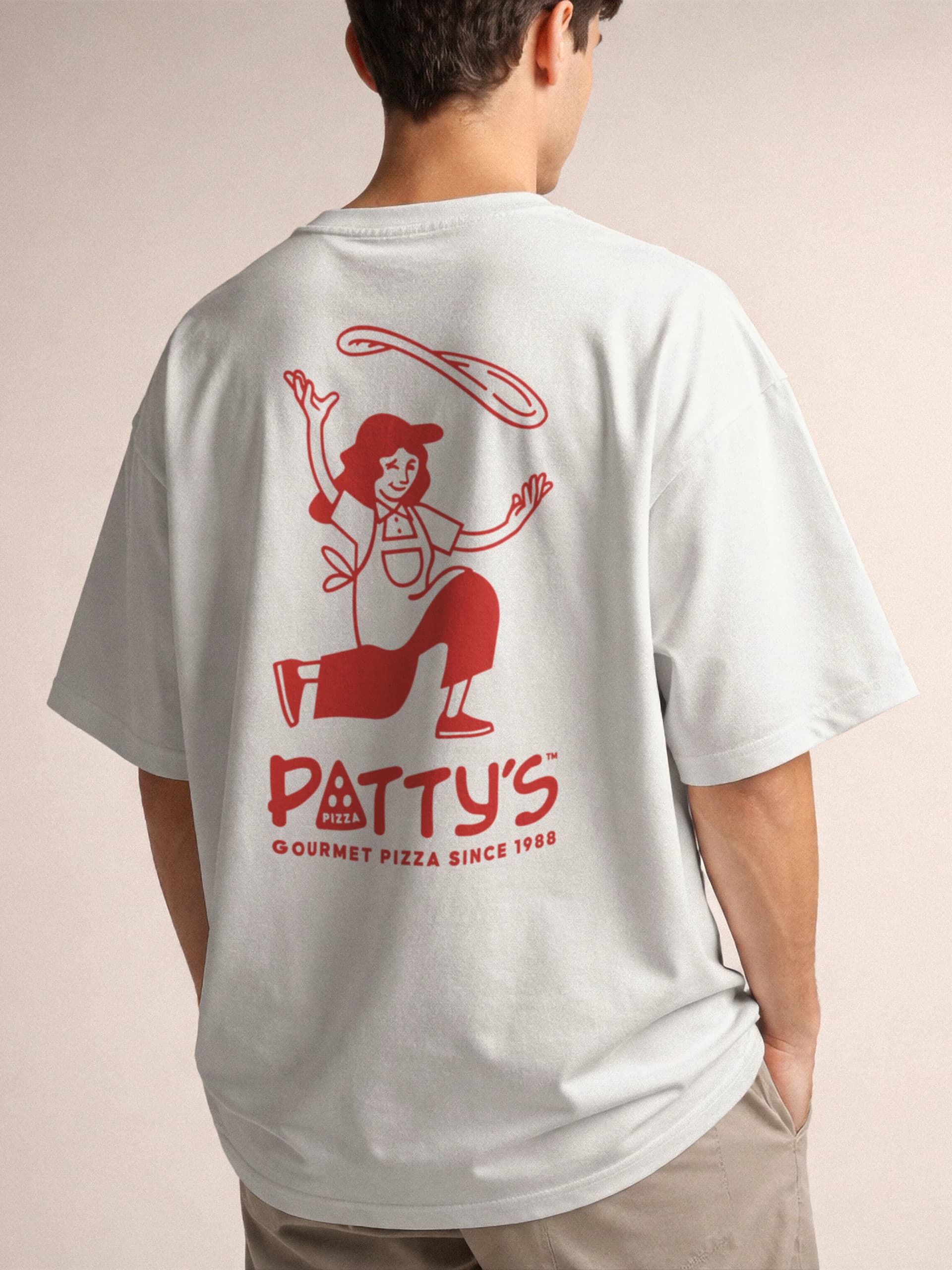 The back of a white t-shirt printed in red with the dough-tossing character and the Patty's logo.